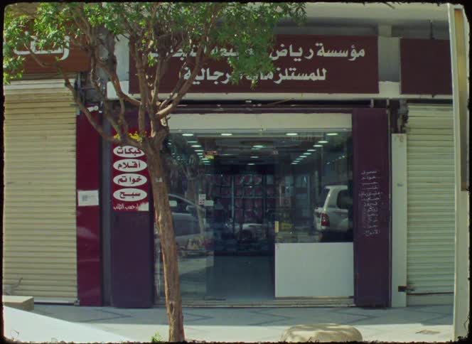 A small storefront with a sign in arabic script suggesting its a shop selling various goods