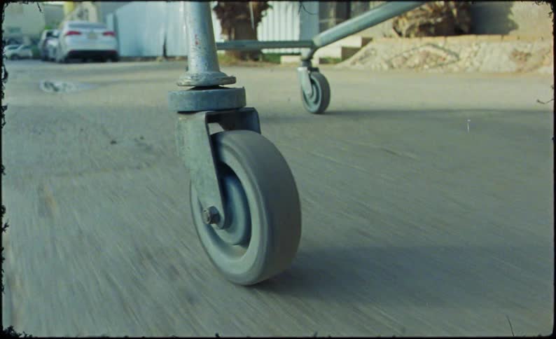 Close up of a shopping cart moving down a street