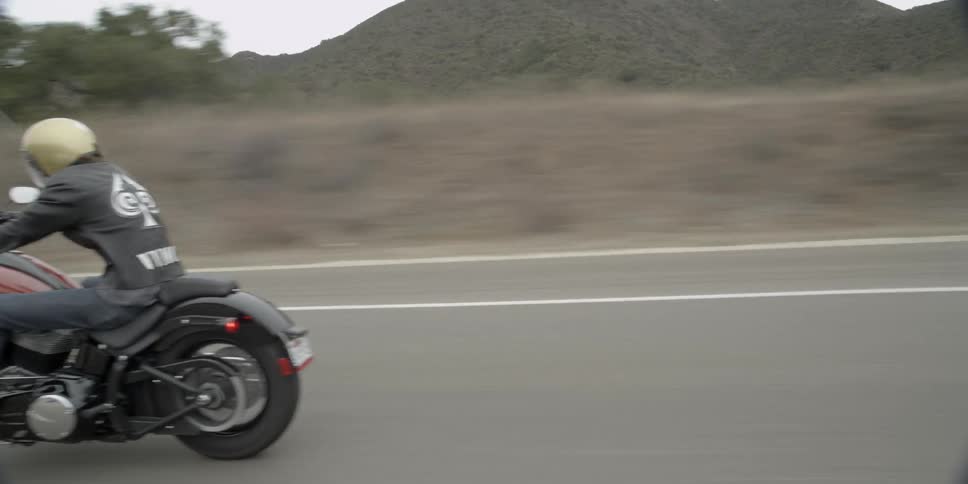 A man is riding a motorcycle on a mountain road
