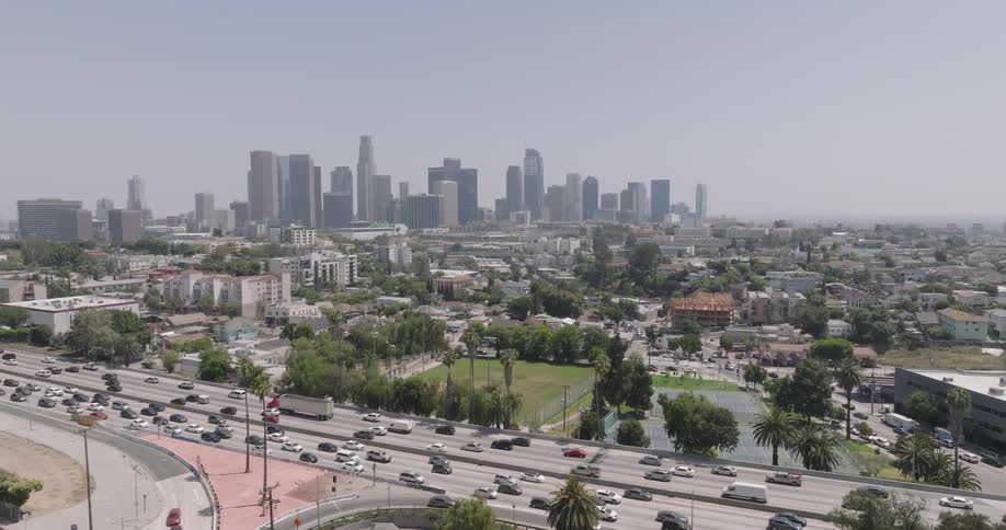 A wide aerial view of los angeles capturing the citys iconic skyline sprawling neighborhoods and busy freeways