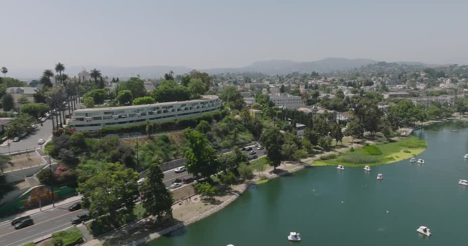 Aerial panorama of an urban city on the edge of a lake with mountains on the horizon