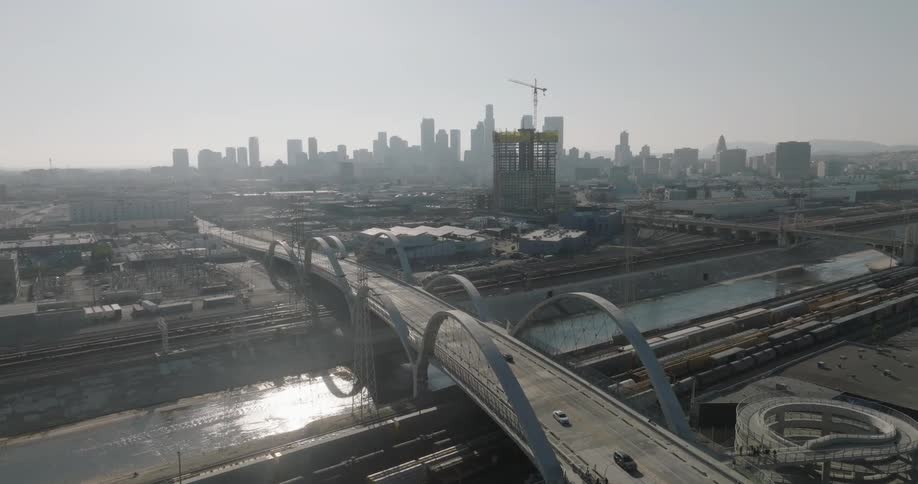 An aerial view of los angeles capturing the citys skyline the 6th street viaduct under construction and the surrounding urban landscape