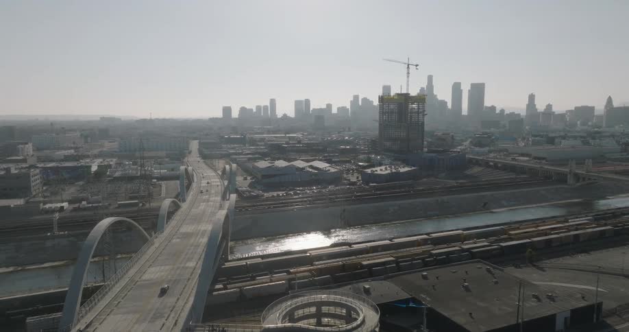 The 6th street viaduct in los angeles under construction with the city skyline in the background