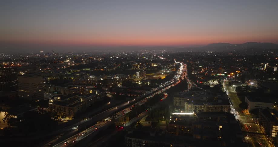 Aerial of highway traffic in an urban area at dusk