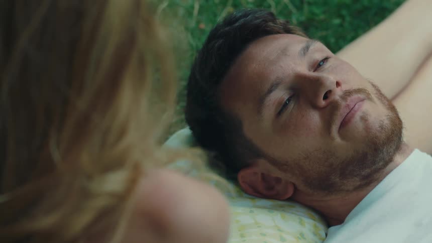 Cheerful man lying down talking to a woman next to him