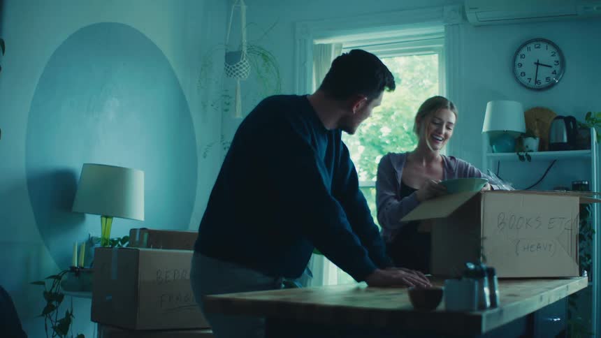 Man and woman talking in a room with a moving box