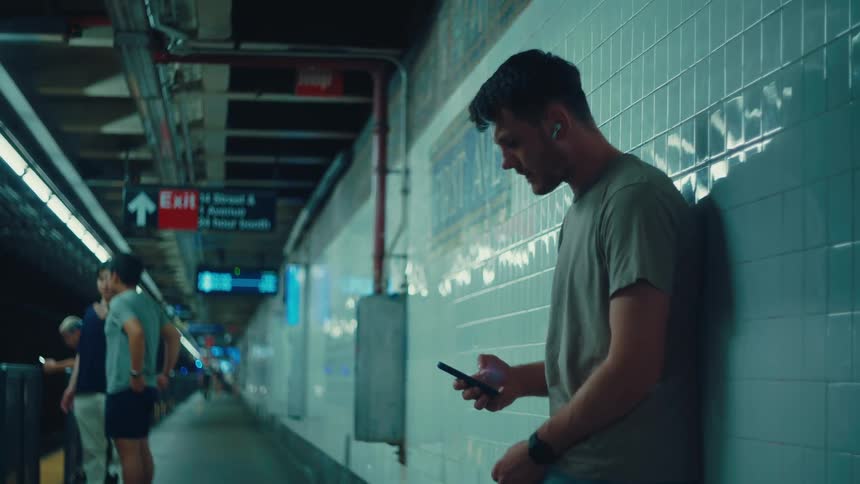 Man interacting with a smartphone on a subway