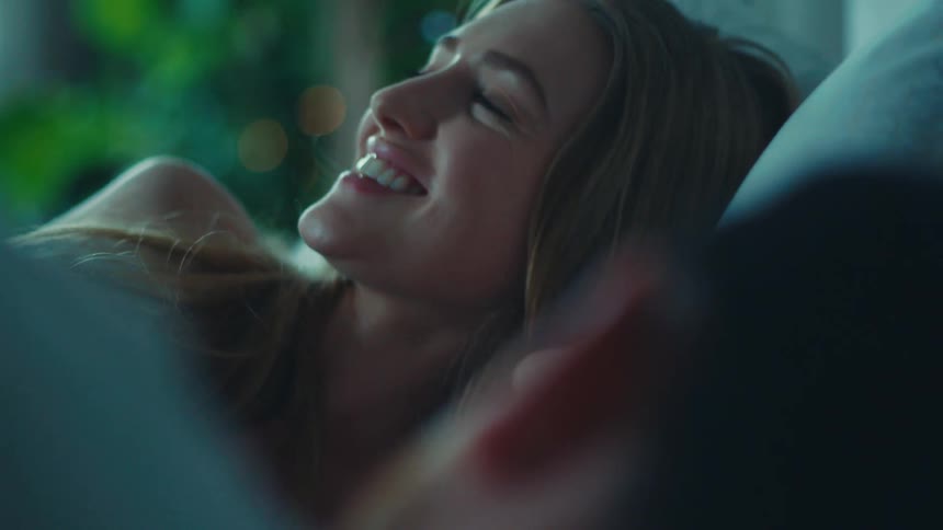 Happy woman lying in bed with a man
