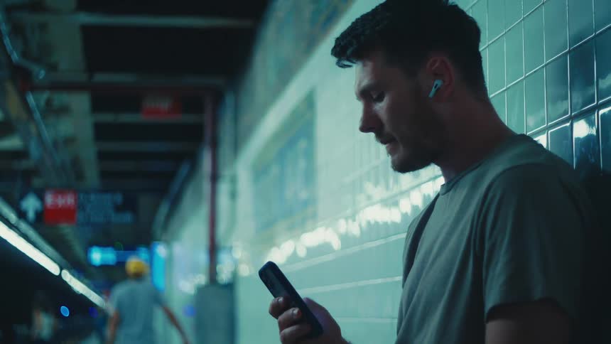 A clip of a man standing and operating a smartphone