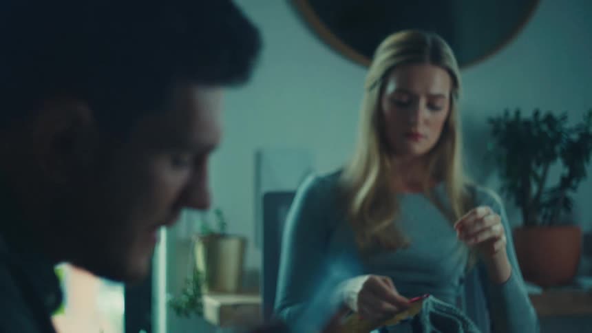 Man sitting at table talking to a woman