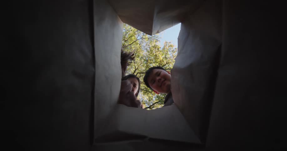 A footage of kids throwing trash into the trash bin