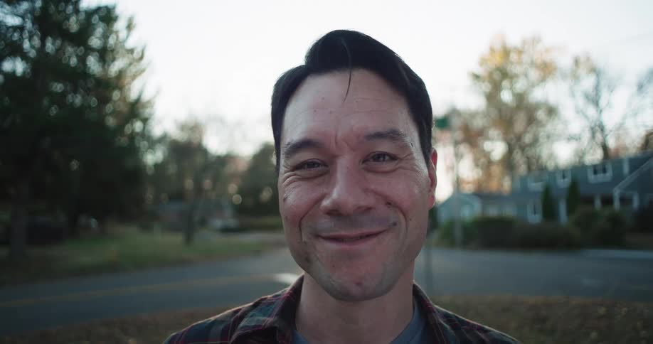 A man is smiling outside