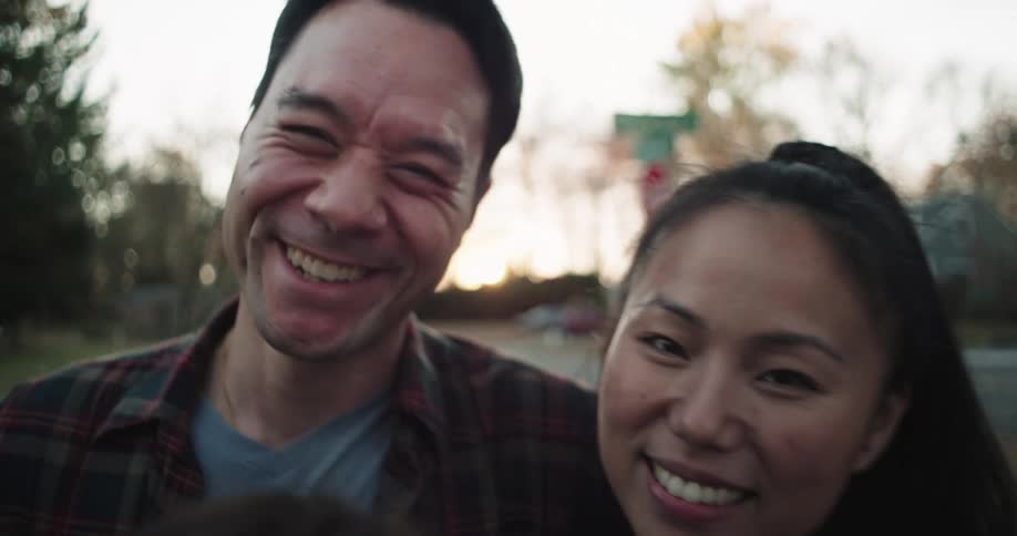 Portrait of a happy family hugging each other while standing in the backyard of a residential neighborhood