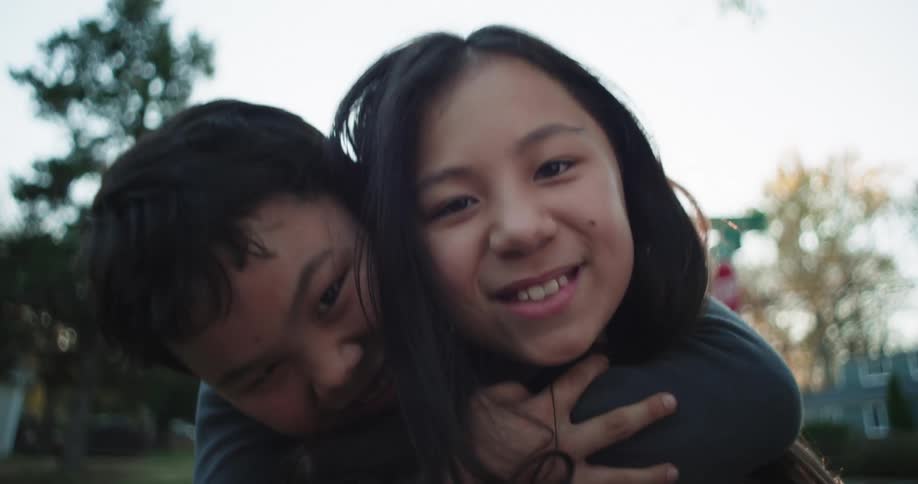 Girl carrying her brother on her back