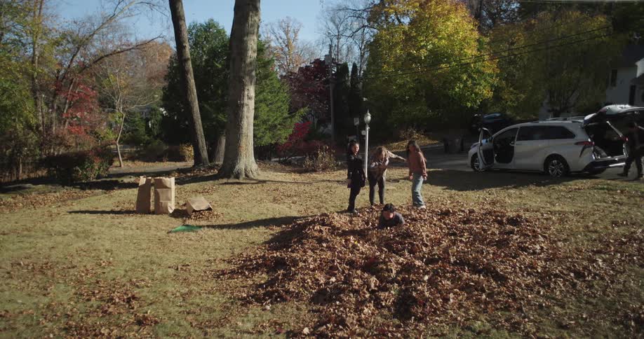 Family playing in a garden with leaves