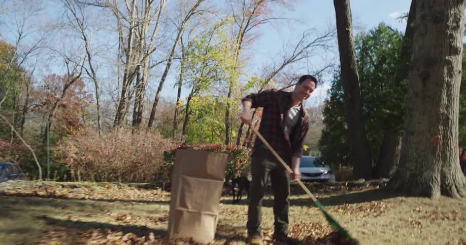 A footage of a man raking and kids playing