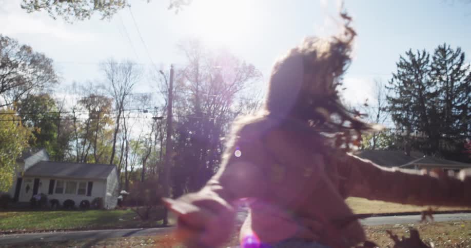 Two children play in the leaves outside