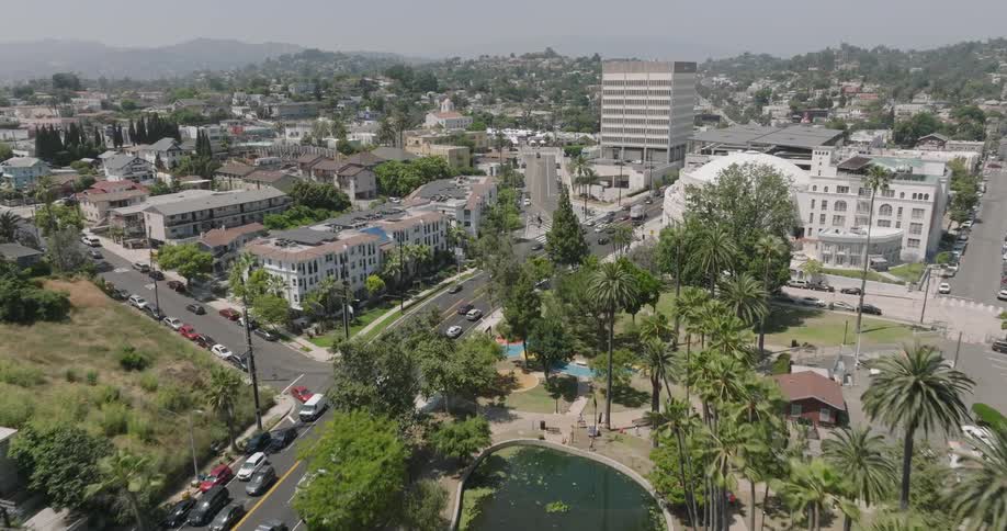 An aerial view of echo park lake in los angeles with its iconic swan boats and surrounding palm trees nestled amidst a residential neighborhood