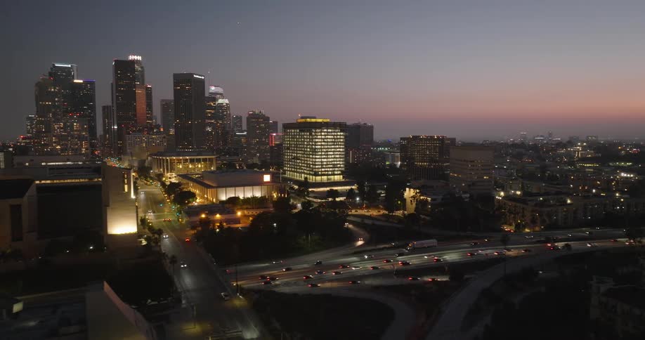 The los angeles skyline illuminated at night with the iconic skyscrapers standing tall against the twilight sky