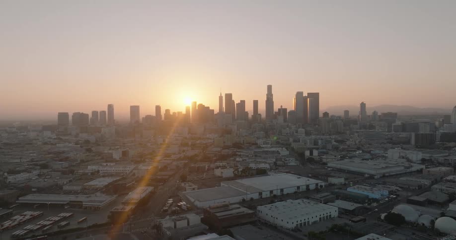 A sunrise over the los angeles skyline with the sun casting a warm glow on the citys towering skyscrapers