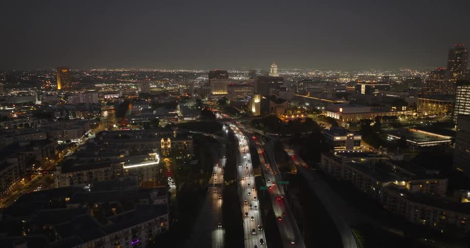 Commuters on a busy highway driving through a metropolitan city at night
