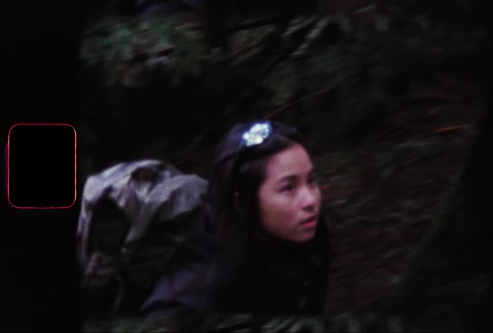 Woman with a backpack walking along a forest trail