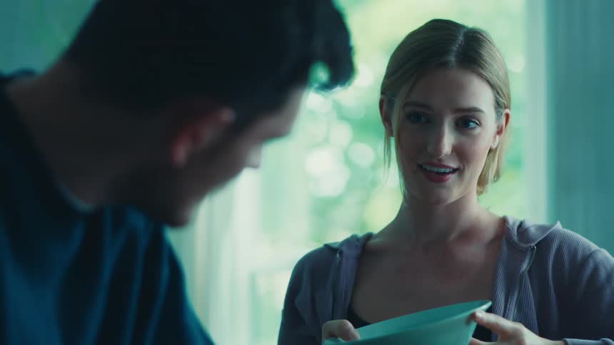 Woman holding a blue pot and talking to a man