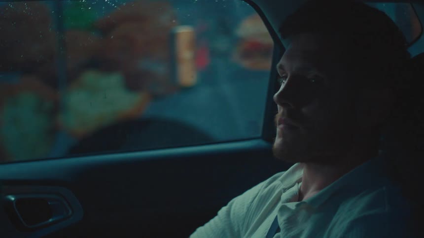 Man sitting in the back seat of a moving vehicle