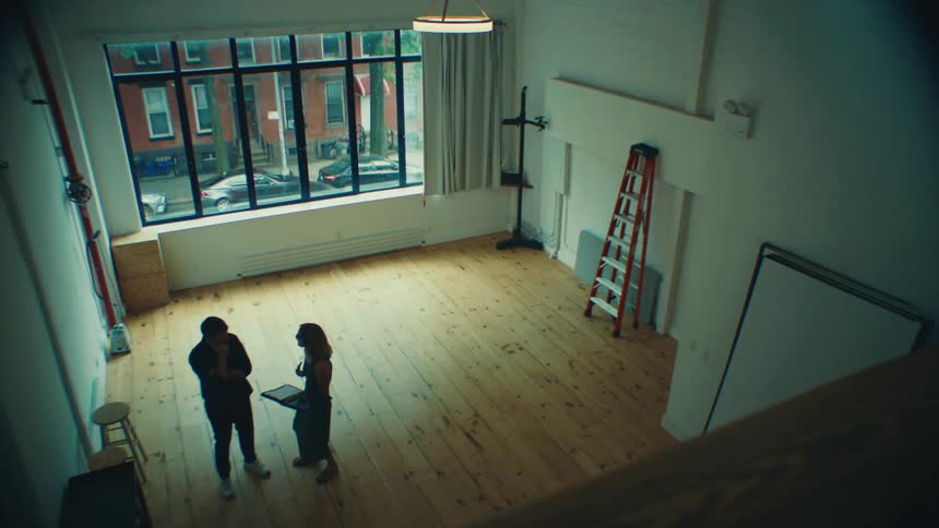 Woman with a book talking to a man in a room