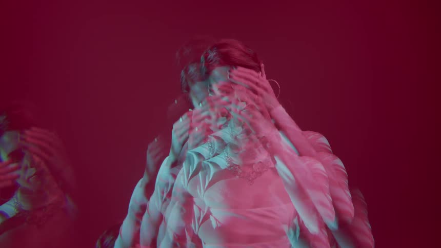 Female model performing in an indoor space against a red background