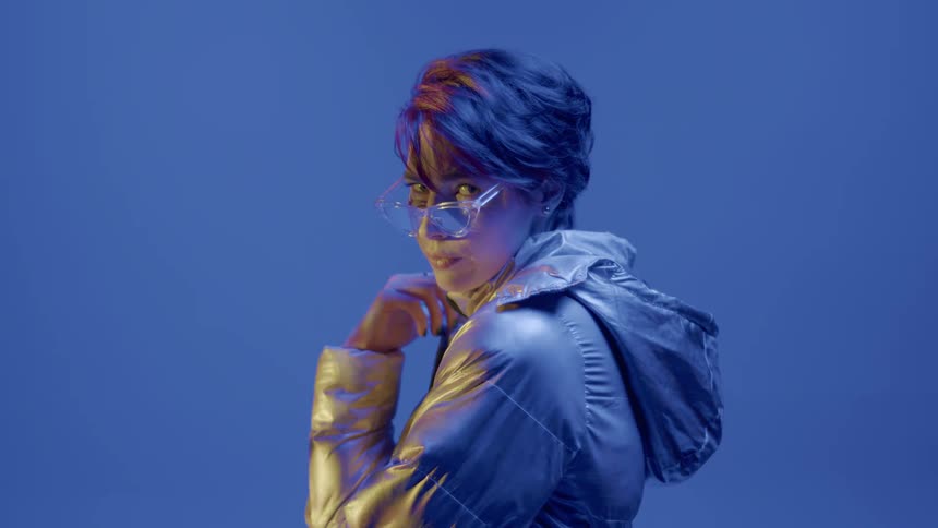 Female model in a performance with a silver jacket and glasses