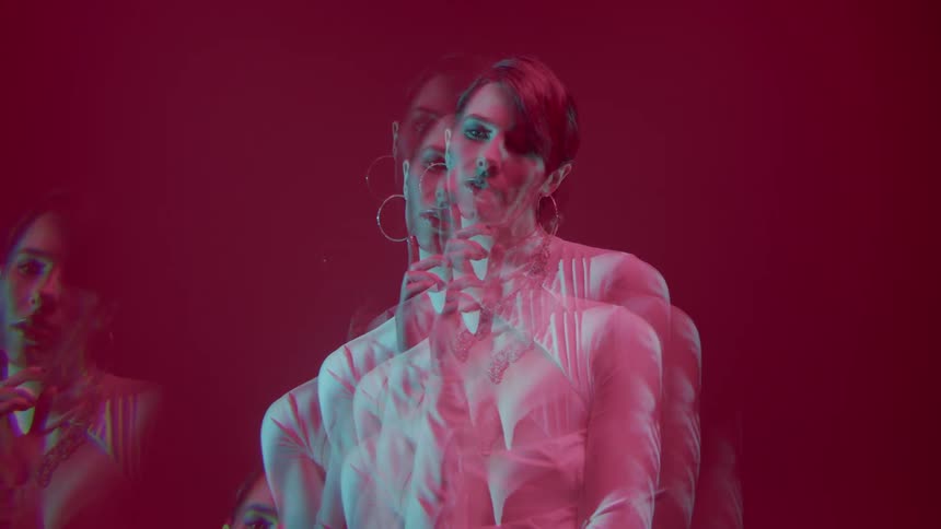 Multiple exposure of a woman in a white outfit in an indoor space with a pink background