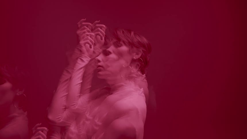 Multiple exposure portrait of a woman in an indoor space against a red background