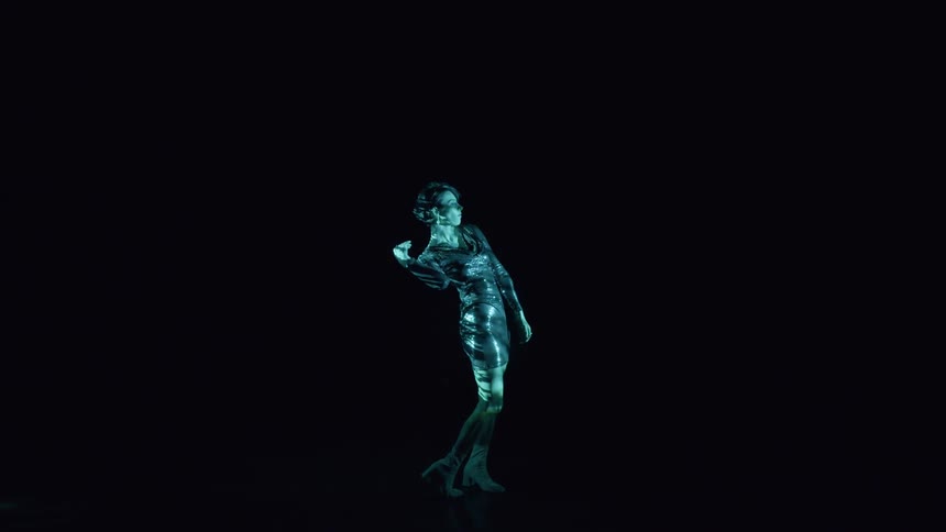 Woman in dress performing with spotlight in dark room