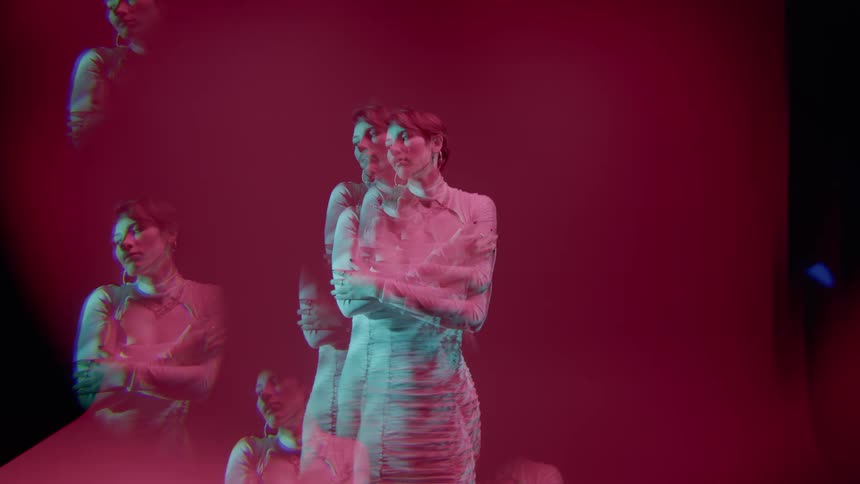 Woman wearing a dress dancing with magenta background