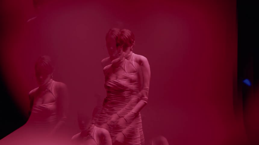 A woman is dancing in a dark area