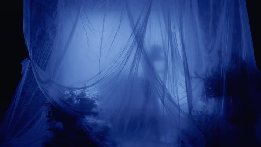 Shadow of a person moving against a background of curtains and a dark room