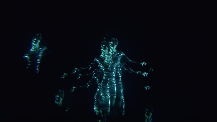 Human body with blue light performing in a dark room
