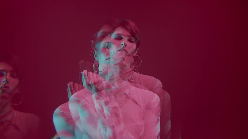 Multiple exposure portrait of a woman in white clothing against a red background