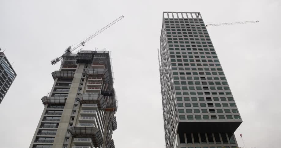 Upward view of buildings under construction on a cloudy day