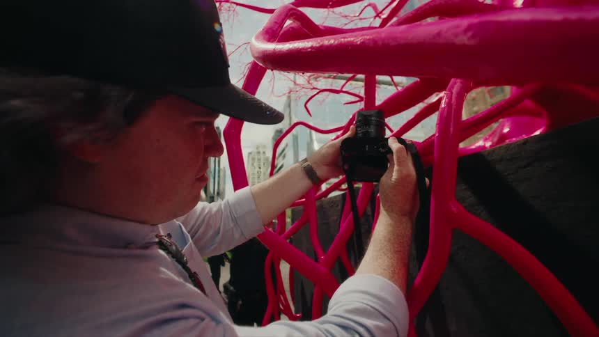 A photographer capturing an image of vibrant pink structures