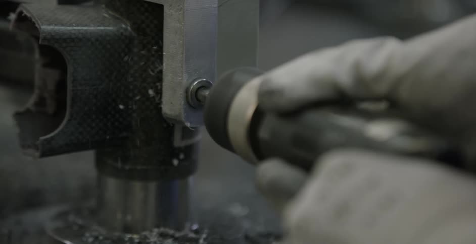A person is using an automatic screwdriver in an industrial setting