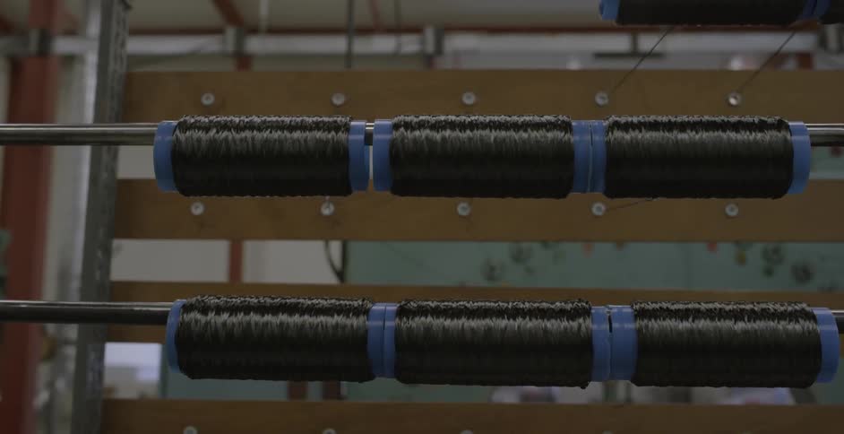 Spools of thread hang from a rack
