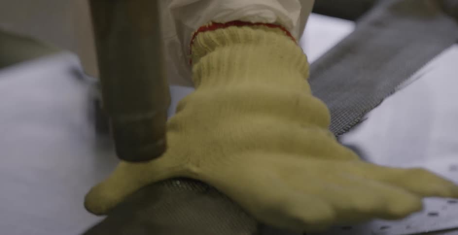 A factory worker smoothes down material