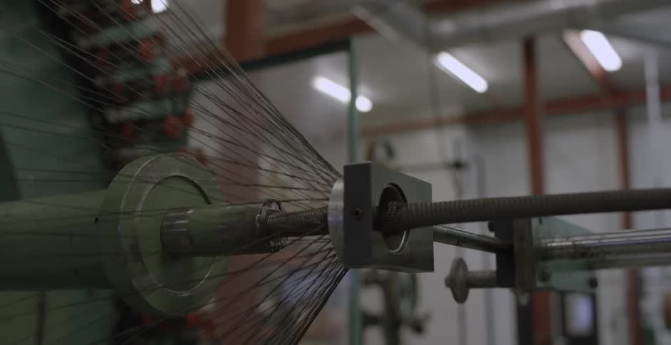 A factory machine weaves a rope