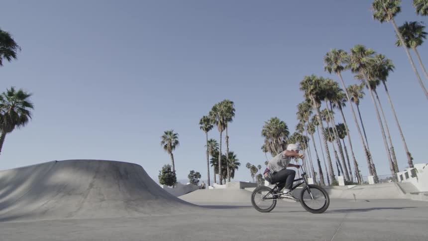 A bicyclist jumps in a skate park