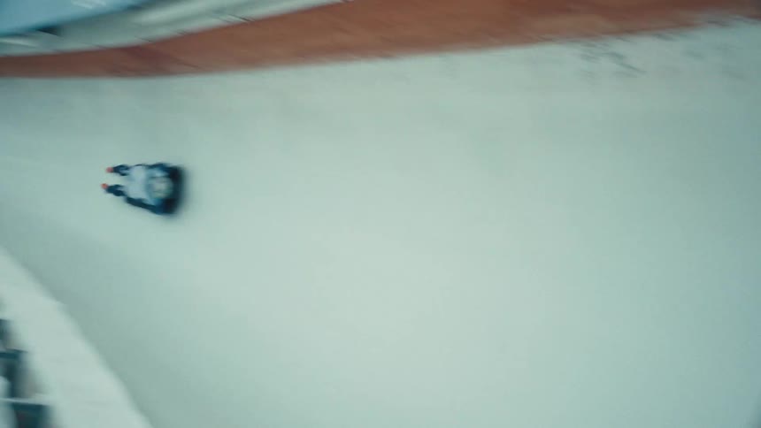 A skeleton racer sliding down an icy track at high speed