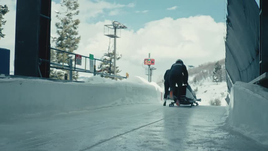 Team on an ice rink starting the bobsled performance