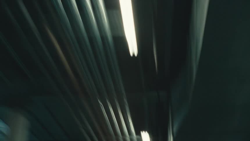 Streaks of light on a subway ceiling caused by rapid movement and bright overhead lights