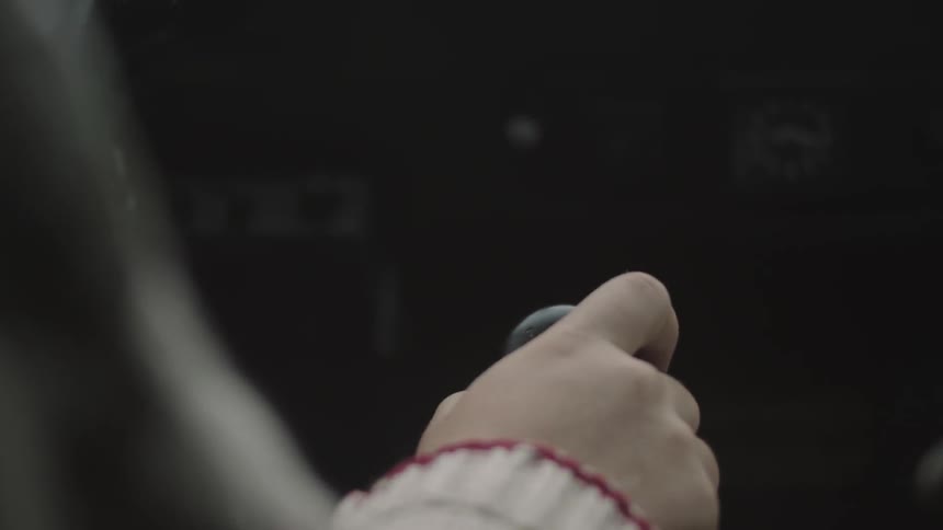 Hand moving a knob in a vehicle